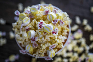 Taffy Town buttered popcorn salt water taffy candy nestled in a bowl of buttery popcorn for movie night snacking